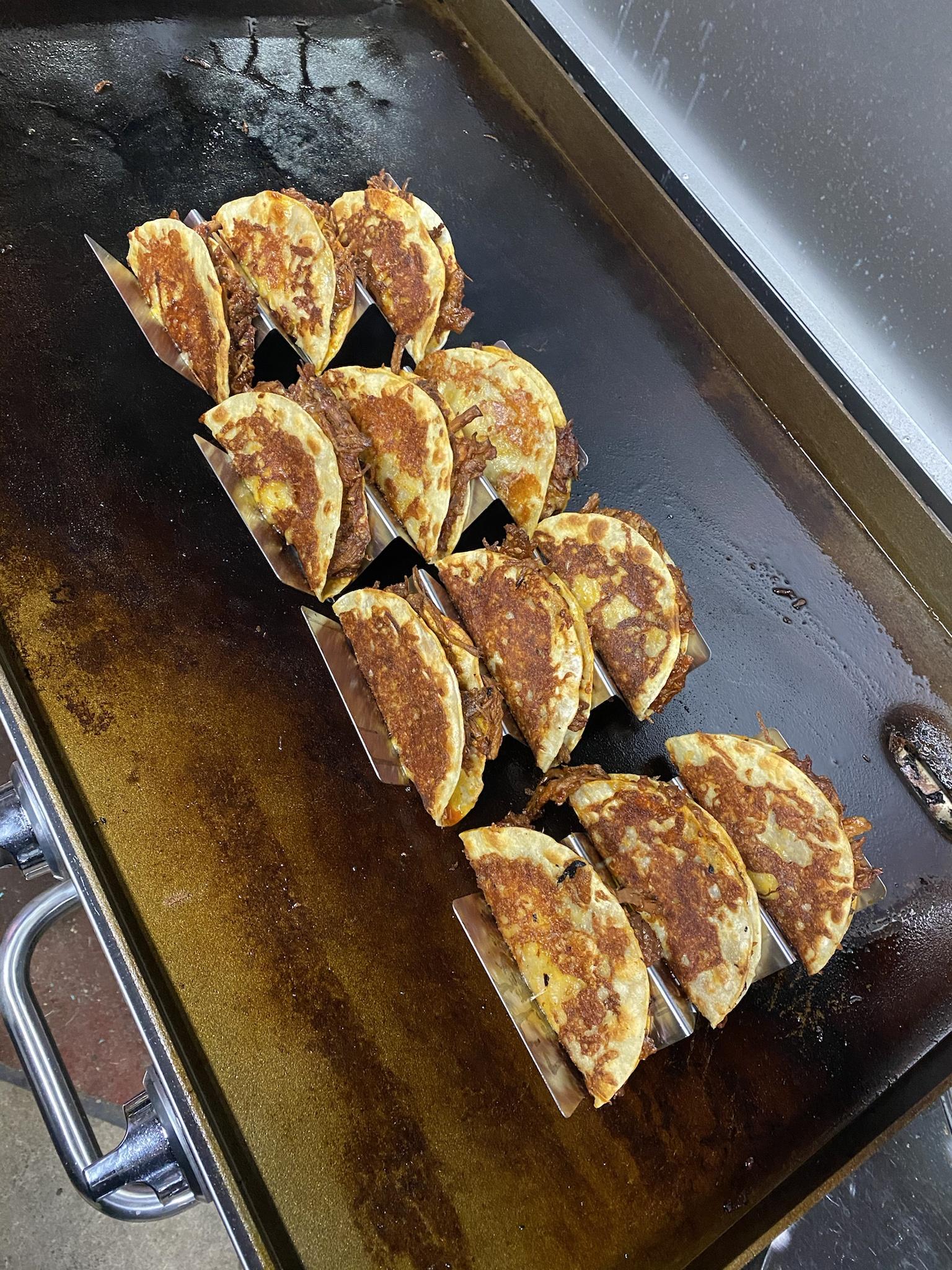 Cheese wrapped birria tacos on the flattop