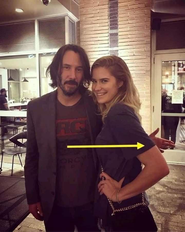 Keanu does not touch any woman while taking pictures with her